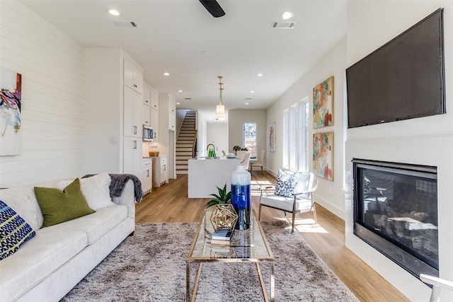 living room featuring light hardwood / wood-style flooring and wood walls