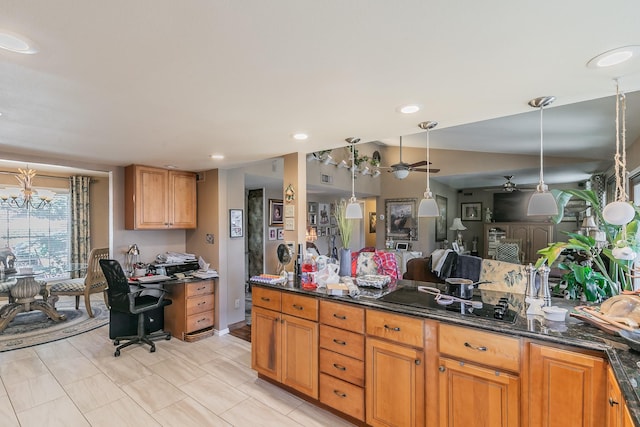 kitchen with pendant lighting, ceiling fan, lofted ceiling, and dark stone countertops