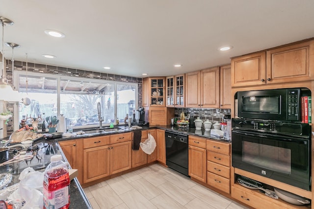 kitchen featuring sink, hanging light fixtures, tasteful backsplash, black appliances, and dark stone counters