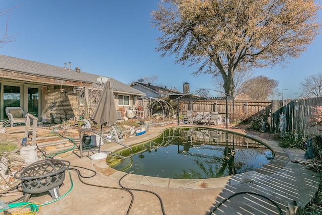 view of swimming pool with a patio area and a fire pit