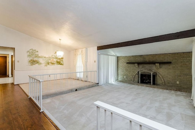 unfurnished living room with dark hardwood / wood-style flooring, vaulted ceiling with beams, and a brick fireplace