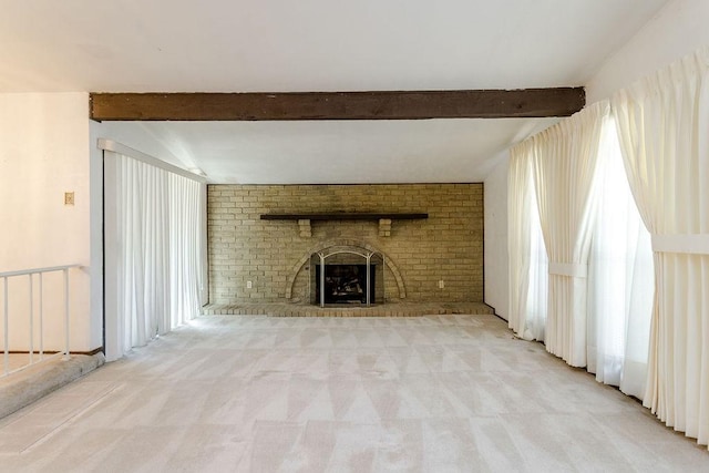 unfurnished living room with beam ceiling, light carpet, and a brick fireplace