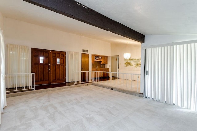 empty room featuring carpet flooring and vaulted ceiling with beams