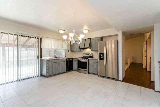 kitchen with appliances with stainless steel finishes, sink, gray cabinetry, an inviting chandelier, and wall chimney exhaust hood