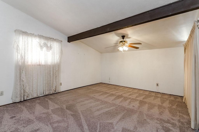 empty room featuring ceiling fan, carpet, and vaulted ceiling with beams