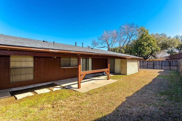 rear view of property featuring a patio and a lawn