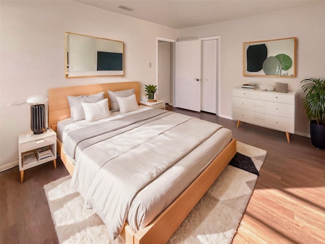 bedroom with dark wood-type flooring and a closet