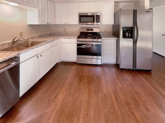 kitchen featuring sink, white cabinetry, light stone counters, dark hardwood / wood-style floors, and stainless steel appliances