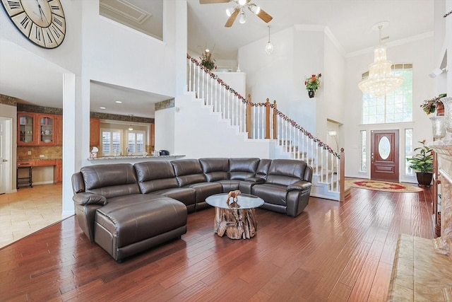 living room featuring a high ceiling, crown molding, dark wood-type flooring, and a notable chandelier