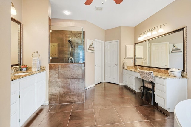 bathroom featuring tile patterned flooring, vanity, a tile shower, and ceiling fan