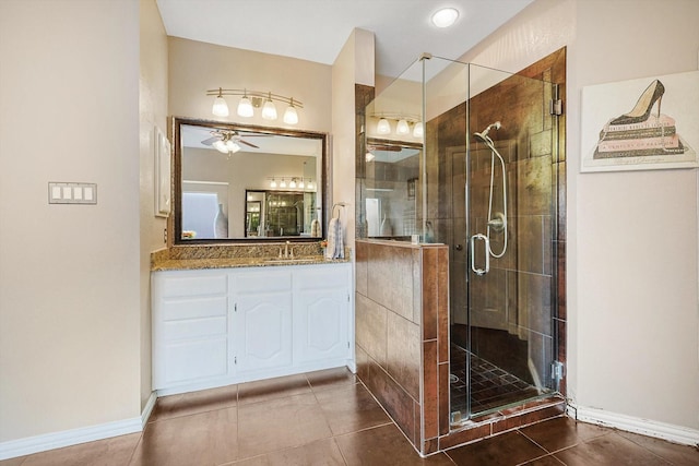 bathroom featuring a shower with door, vanity, tile patterned flooring, and ceiling fan