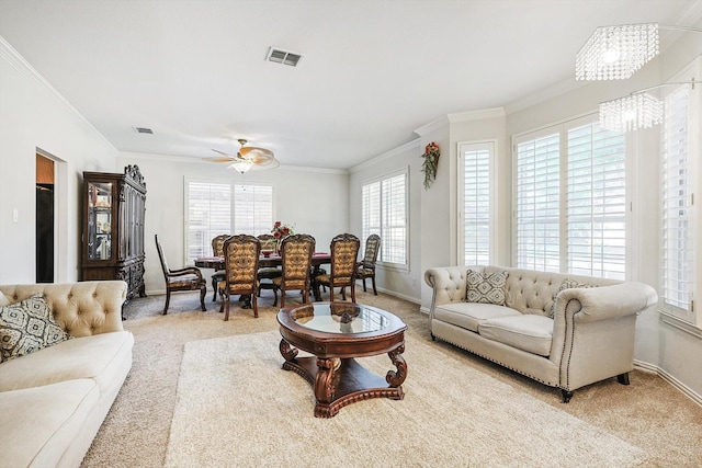 carpeted living room featuring ceiling fan with notable chandelier and ornamental molding