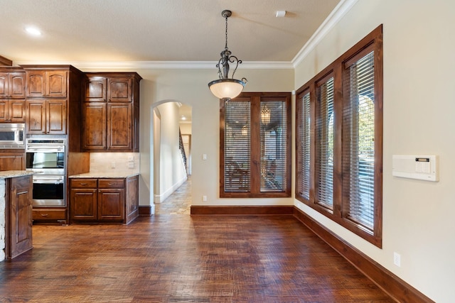 kitchen with crown molding, decorative light fixtures, dark hardwood / wood-style floors, stainless steel appliances, and backsplash