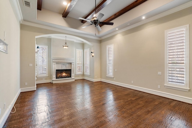 unfurnished living room with crown molding, a premium fireplace, ceiling fan, wood-type flooring, and beamed ceiling