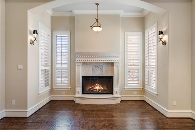 unfurnished living room featuring dark hardwood / wood-style flooring, a fireplace, and ornamental molding