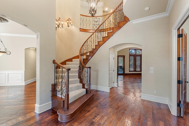 entrance foyer featuring ornamental molding, dark hardwood / wood-style floors, and a high ceiling