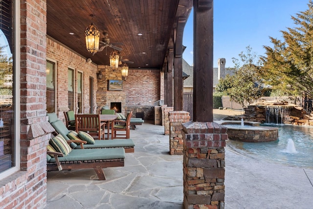 view of patio / terrace featuring ceiling fan and an outdoor stone fireplace