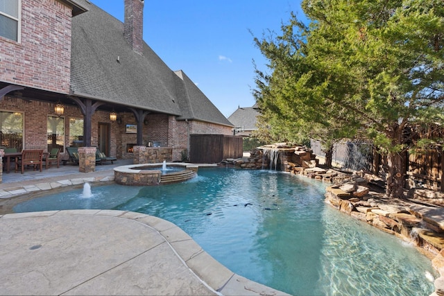 view of pool featuring pool water feature, an in ground hot tub, and a patio