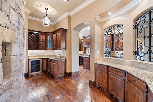 bar featuring wine cooler, hanging light fixtures, ornamental molding, dark hardwood / wood-style flooring, and light stone countertops