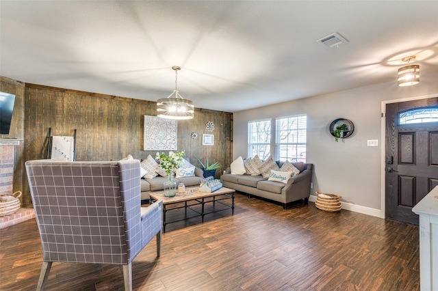 living room featuring dark hardwood / wood-style floors and wood walls