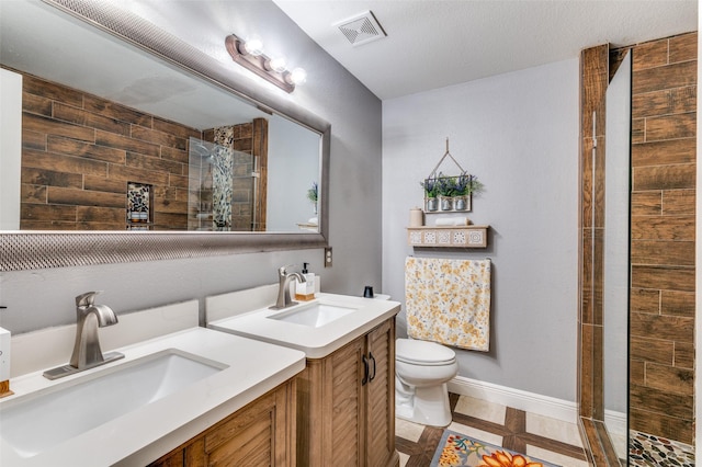 bathroom featuring vanity, toilet, and a tile shower