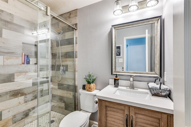 bathroom featuring vanity, a shower with door, and toilet