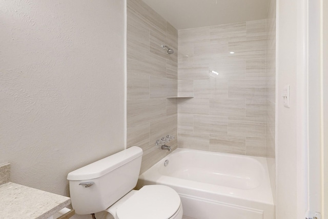 full bathroom featuring tiled shower / bath, vanity, and toilet