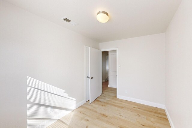 empty room with ceiling fan and light hardwood / wood-style flooring