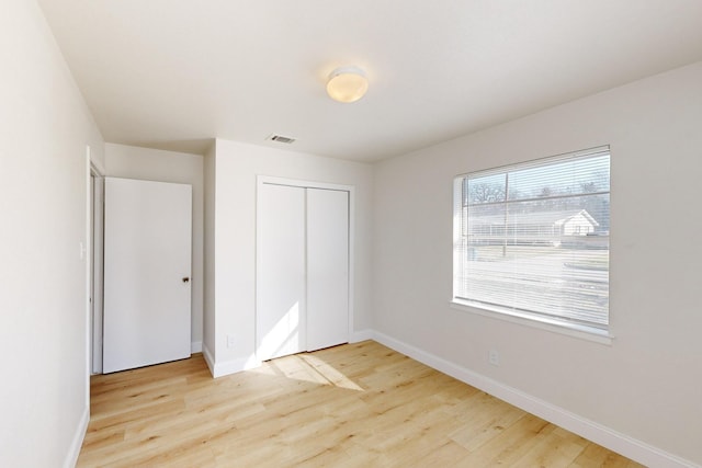 unfurnished bedroom with light hardwood / wood-style floors and a closet