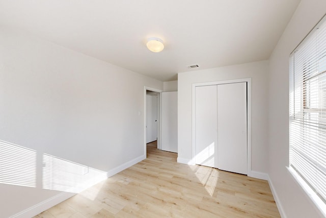 unfurnished bedroom with a closet and light hardwood / wood-style flooring