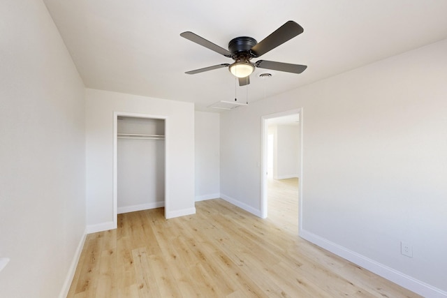 unfurnished bedroom with ceiling fan, a closet, and light wood-type flooring