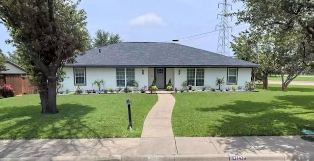 ranch-style home with stucco siding, roof with shingles, a front lawn, and fence