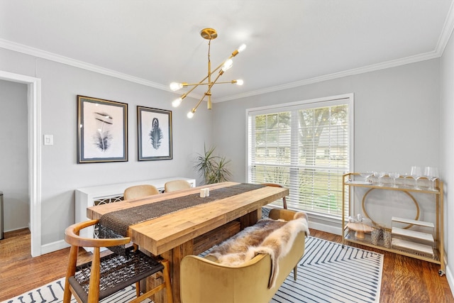 dining space featuring baseboards, an inviting chandelier, wood finished floors, and crown molding