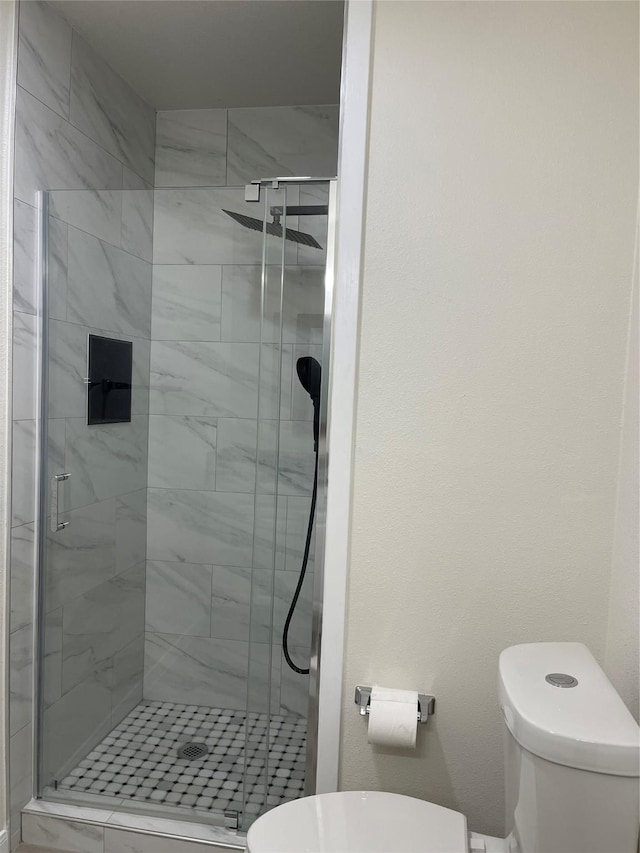 bathroom with an enclosed shower and toilet