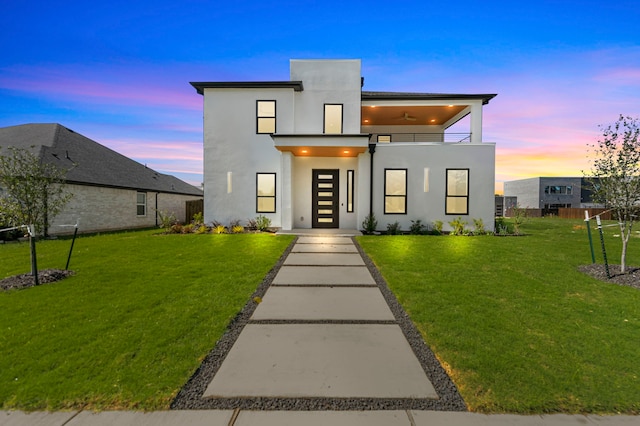 modern home featuring a balcony and a lawn