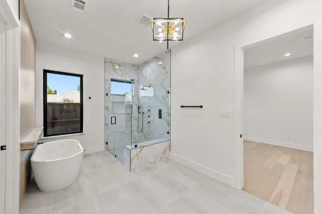 bathroom featuring plus walk in shower and a chandelier