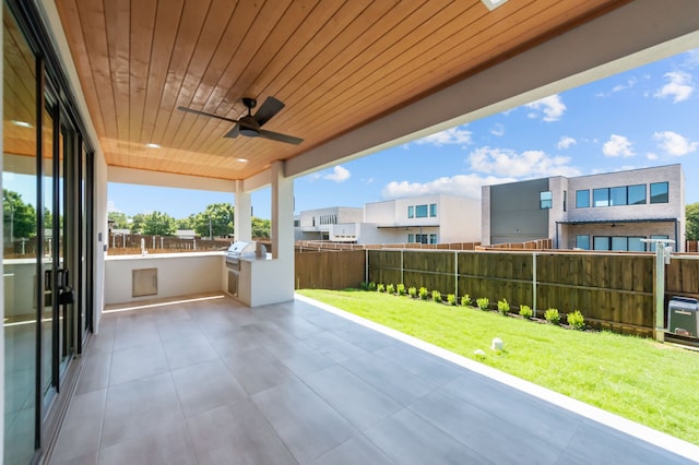 view of patio with an outdoor kitchen and ceiling fan