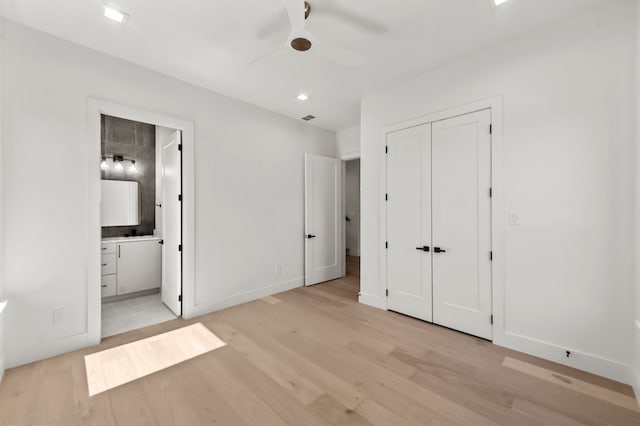 unfurnished bedroom with ceiling fan, ensuite bath, a closet, and light hardwood / wood-style flooring