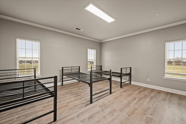 bedroom with crown molding and light wood-type flooring