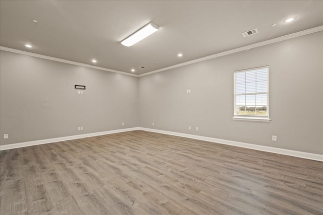 unfurnished room featuring crown molding and light hardwood / wood-style floors