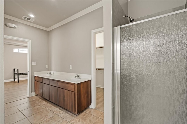 bathroom with an enclosed shower, vanity, crown molding, and tile patterned flooring