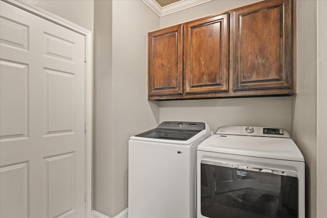 washroom featuring separate washer and dryer, crown molding, and cabinets