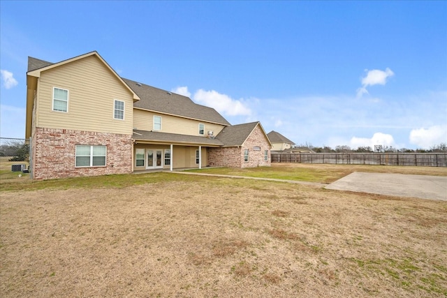 back of property with a lawn and a patio area