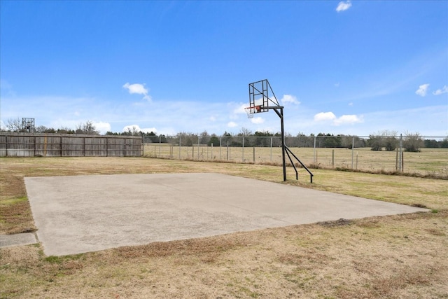 view of basketball court with a lawn and a rural view