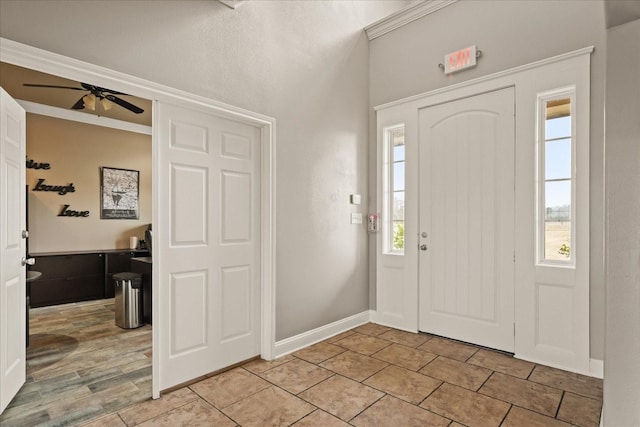 entrance foyer with ornamental molding, light tile patterned flooring, a ceiling fan, and baseboards