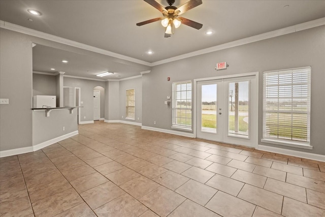 empty room featuring crown molding, light tile patterned floors, ceiling fan, and french doors