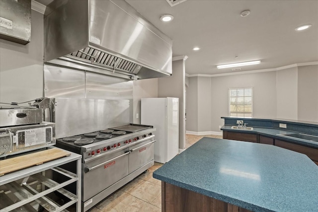 kitchen featuring double oven range, sink, ornamental molding, and wall chimney range hood