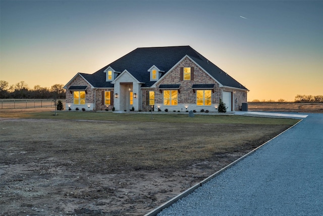 view of front of property featuring a garage and a lawn