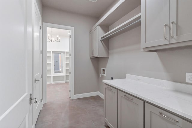 washroom featuring washer hookup, cabinets, a notable chandelier, and electric dryer hookup