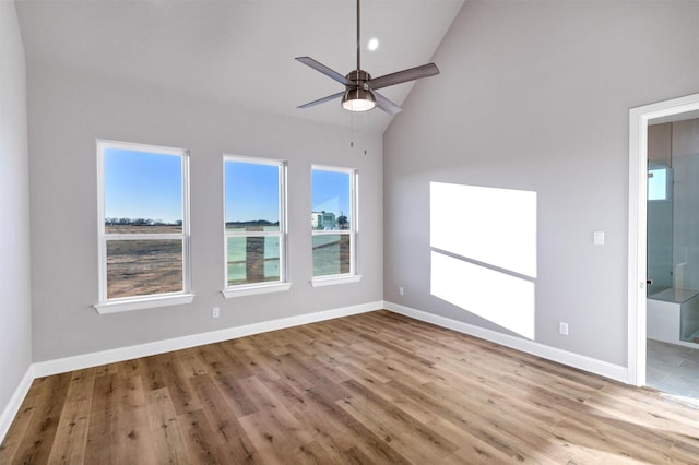 spare room with high vaulted ceiling, ceiling fan, and light hardwood / wood-style flooring